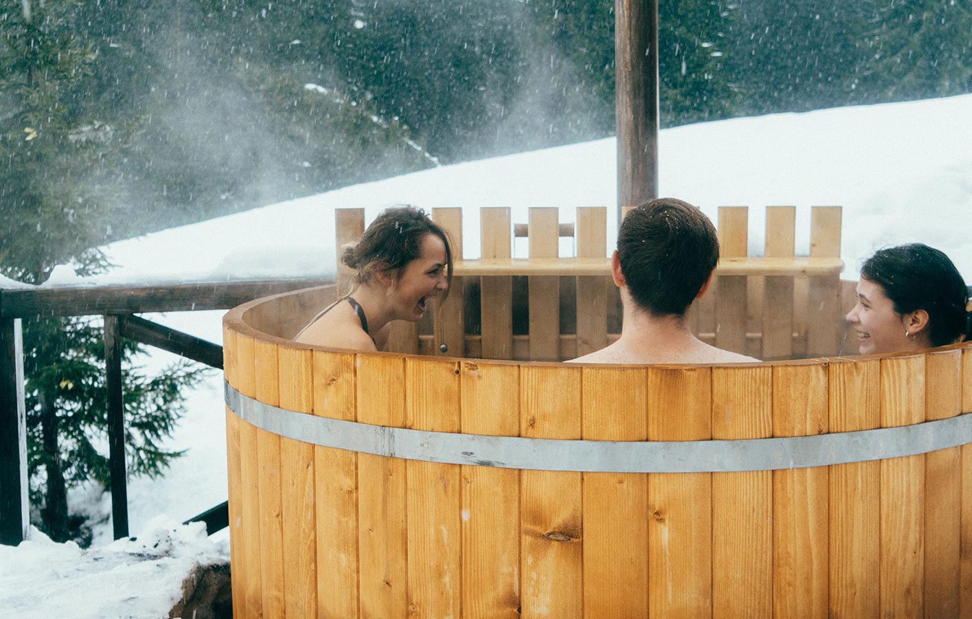 Jugendliche sitzen im hot tube im Winter